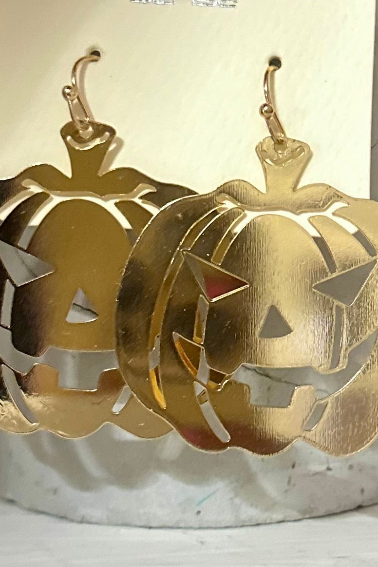 A pair of gold-colored pumpkin-shaped earrings displayed against a white and gold card.