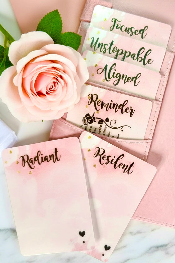 Pink planner with motivational stickers and a rose on a marble surface