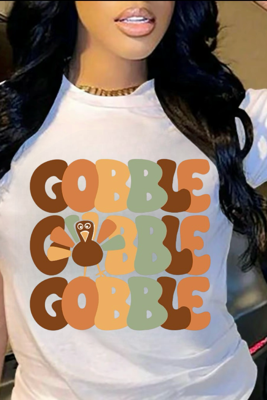 A woman wearing a white t-shirt with the text 'GOBBLER' and a turkey design in a Thanksgiving themed image.
