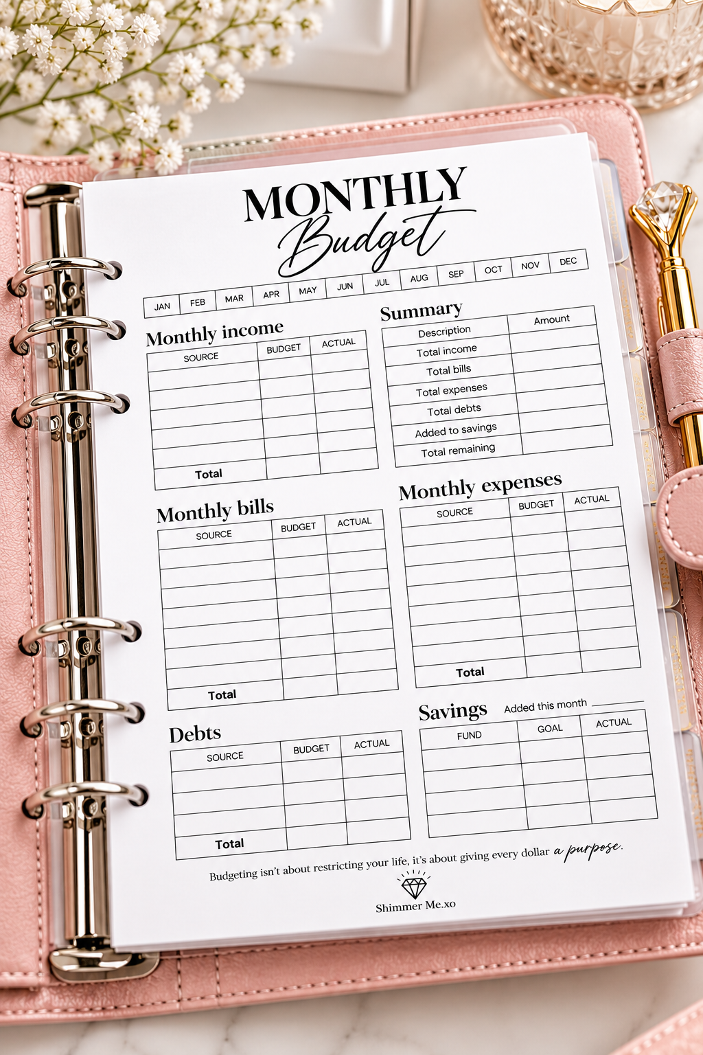 A monthly budget planner insert page displayed in a pink ring binder, with decorative flowers and a gold-toned accessory in the background.